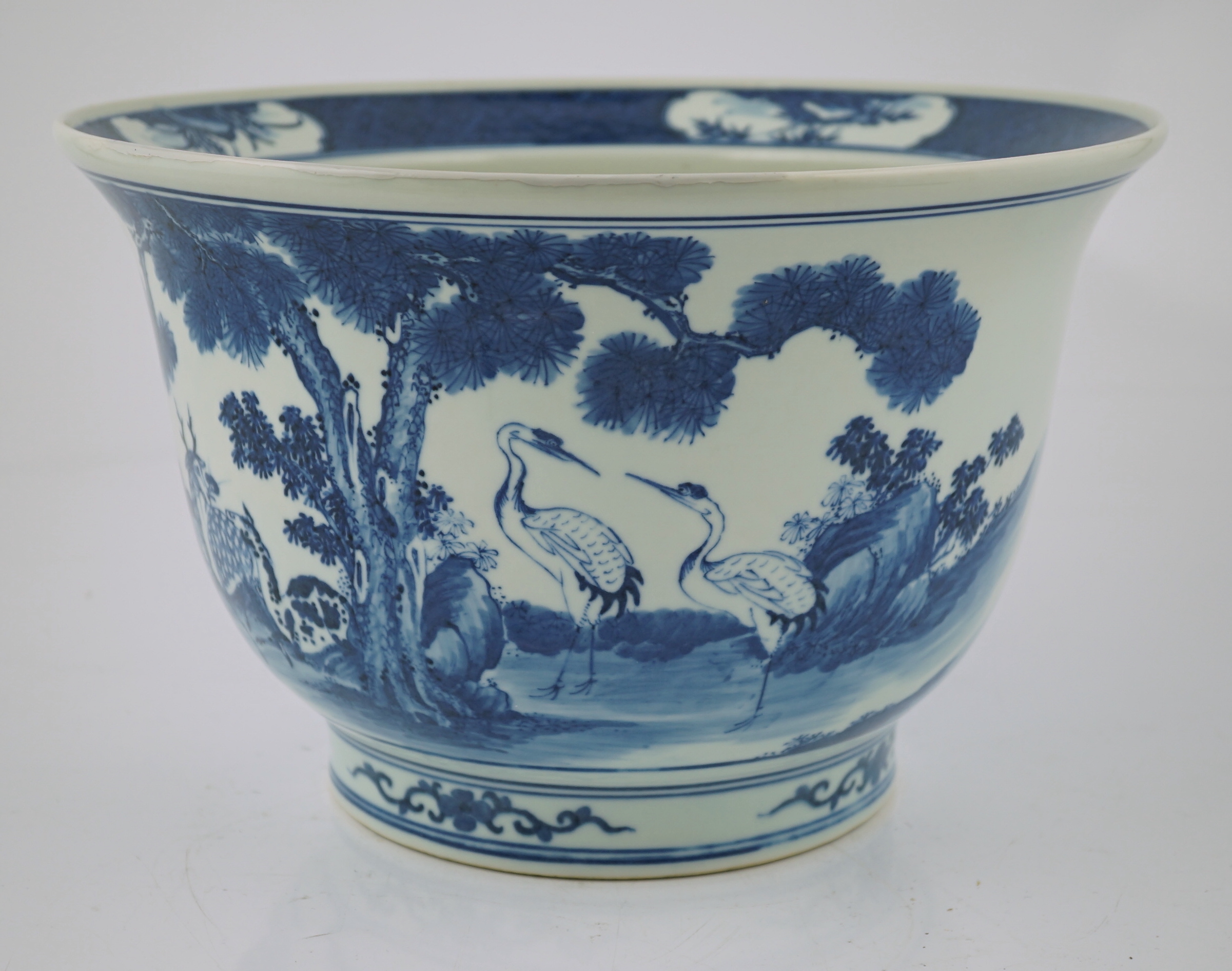 A Chinese blue and white 'deer and cranes' planter, 19th century, restoration to rim and a crack to the base